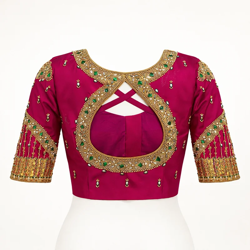 Magenta bridal blouse with intricate maggam work embroidery — teardrop back, green stones and gold zari — Akira Fashion Studio Bangalore