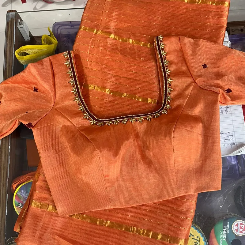 Orange blouse with gold lace border trim and small embroidery accents