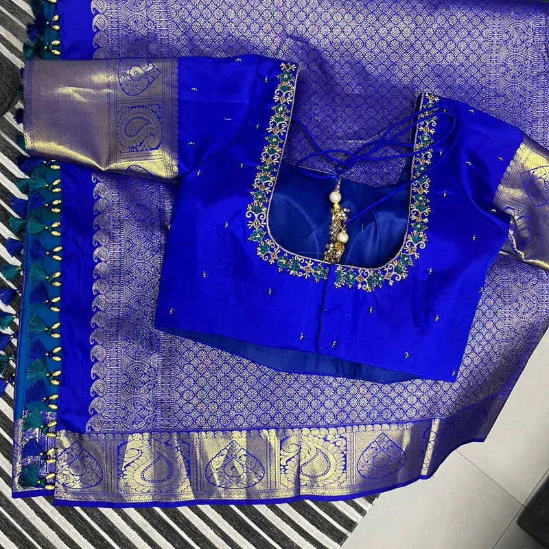 Royal blue hand embroidery blouse paired with a blue Banarasi saree