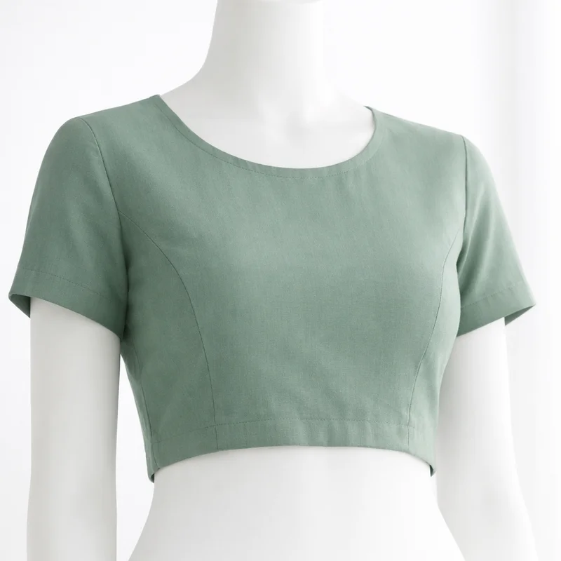 Sage green custom-stitched blouse on mannequin — Akira Fashion Studio