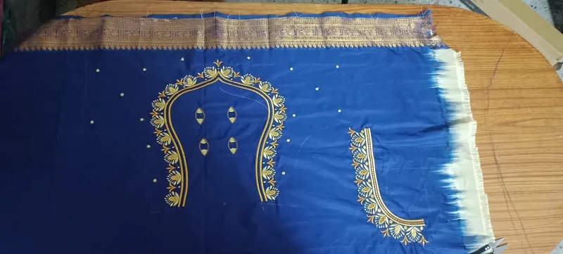 Blue fabric with gold thread neckline and sleeve embroidery pattern