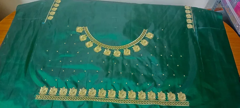 Green blouse with gold pendant-style neckline embroidery