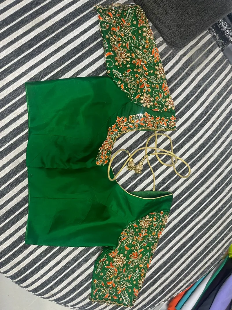 Green blouse with dense gold and orange embroidery — front view