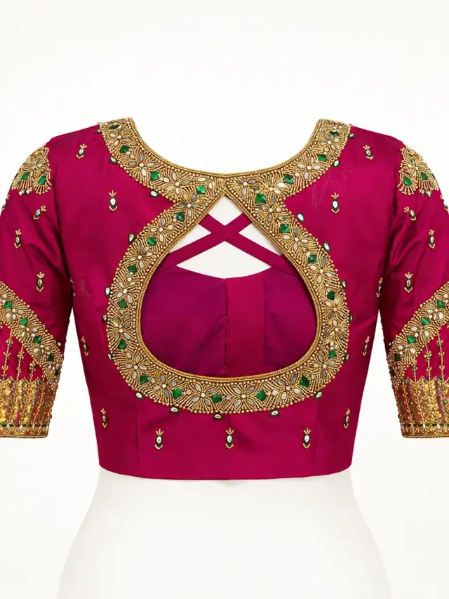 Magenta bridal blouse with intricate maggam work embroidery — teardrop back, green stones and gold zari — Akira Fashion Studio Bangalore