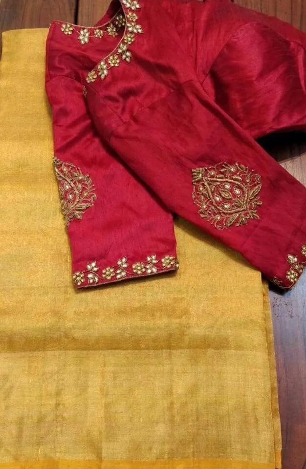 Maroon blouse with gold embroidery motifs on sleeves, paired with gold saree