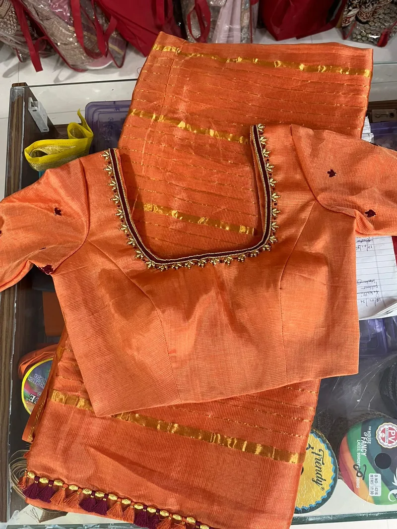 Orange blouse with gold lace border trim and small embroidery accents