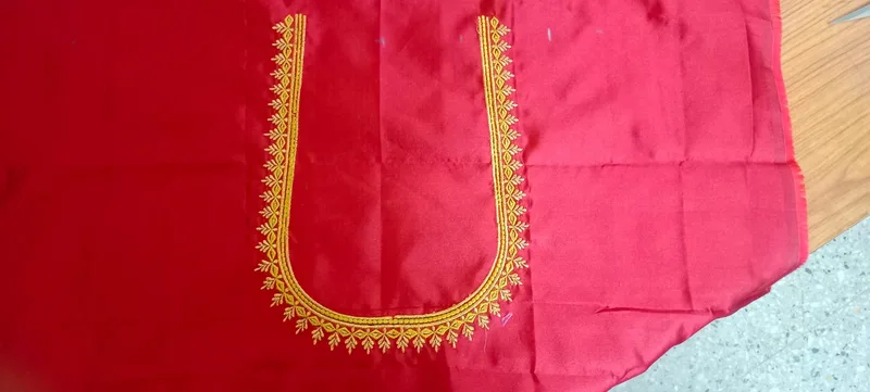Red blouse fabric with gold embroidery along deep neckline