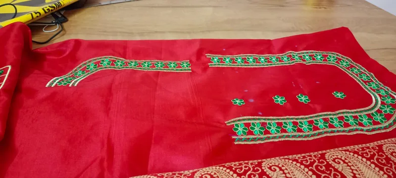 Red fabric with green and gold border embroidery work